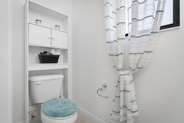 bathroom featuring tile floors and toilet