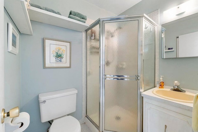 bathroom featuring vanity, a shower with shower door, and toilet