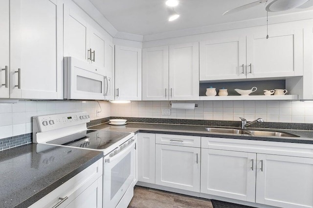 kitchen with white cabinetry, white appliances, and sink