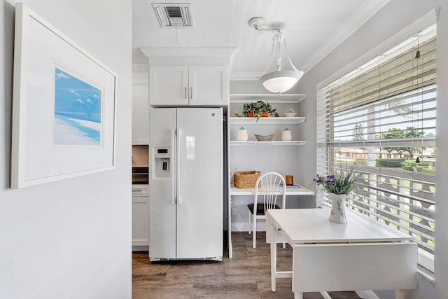 kitchen featuring pendant lighting, white cabinetry, white refrigerator with ice dispenser, and dark wood-type flooring