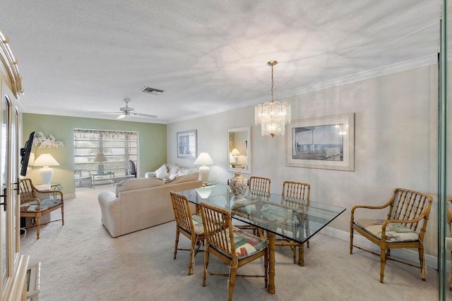 carpeted dining space with ceiling fan with notable chandelier, a textured ceiling, and ornamental molding