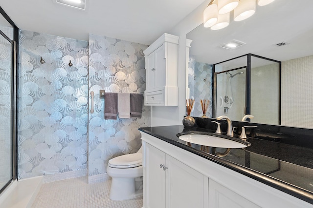 bathroom featuring tile patterned flooring, vanity, a shower with door, and toilet