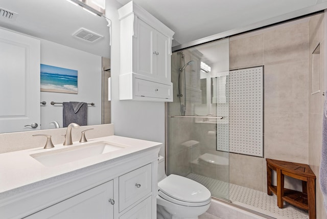 bathroom with vanity, toilet, and a shower with shower door