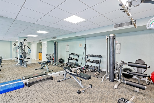 workout area featuring carpet and a drop ceiling