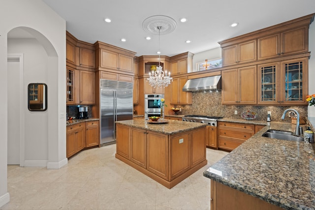 kitchen with backsplash, a kitchen island, stainless steel appliances, wall chimney exhaust hood, and sink