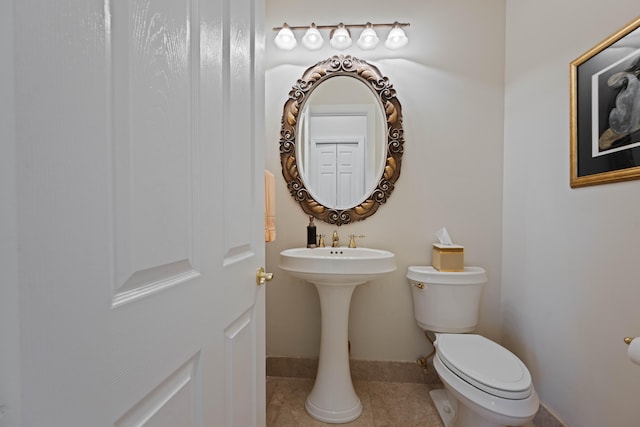 bathroom featuring tile flooring and toilet