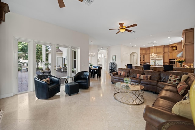 living room featuring light tile flooring and ceiling fan with notable chandelier