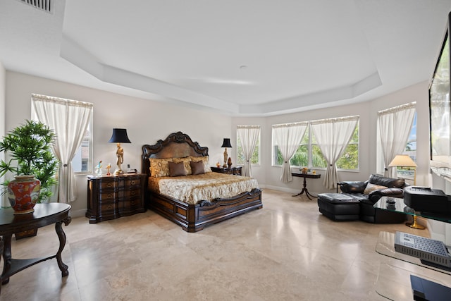 bedroom featuring a raised ceiling and tile floors