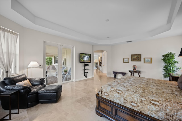 tiled bedroom featuring a tray ceiling and access to exterior