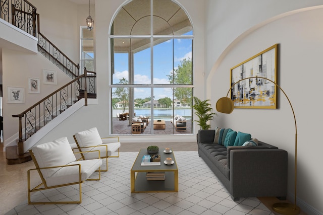 living room with a water view and a towering ceiling