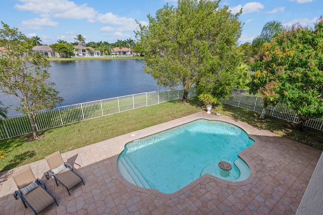 view of swimming pool featuring a patio area, a water view, and a lawn