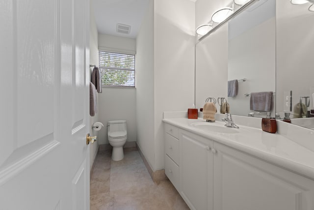 bathroom featuring vanity, tile floors, and toilet