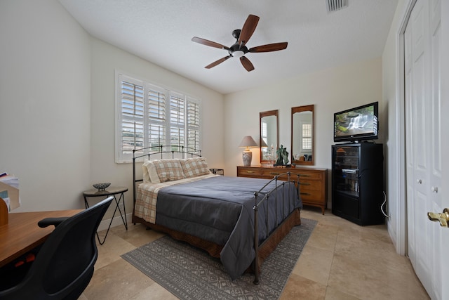 bedroom featuring a closet, ceiling fan, and light tile floors