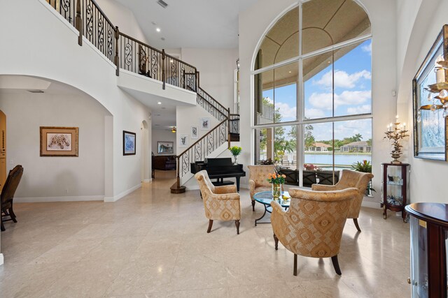 interior space featuring a water view, a wealth of natural light, and a high ceiling