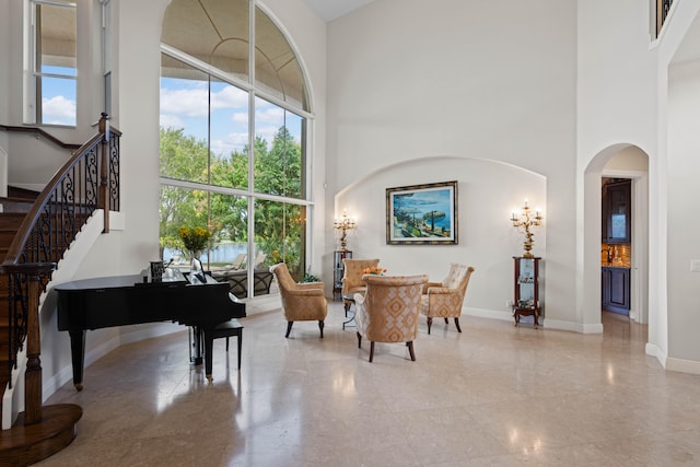 sitting room with a wealth of natural light, tile floors, and a high ceiling