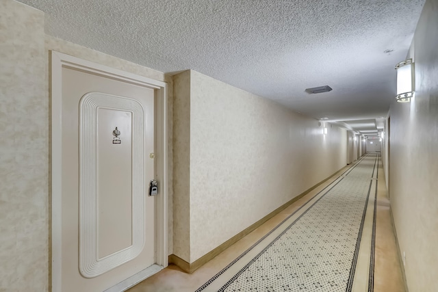 hallway with a textured ceiling