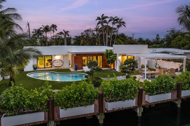 pool at dusk with a patio