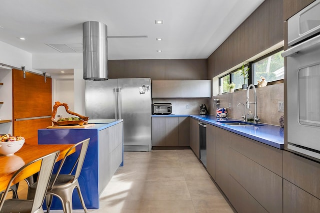 kitchen featuring light tile flooring, backsplash, stainless steel appliances, and sink