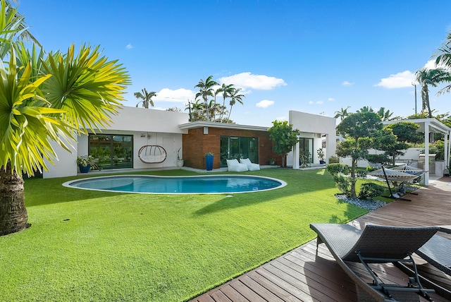 view of swimming pool with a deck and a yard