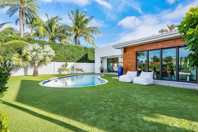 view of pool with a yard