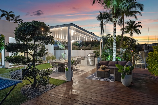 deck at dusk featuring outdoor lounge area and area for grilling