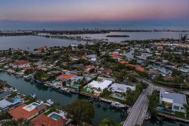 aerial view at dusk featuring a water view