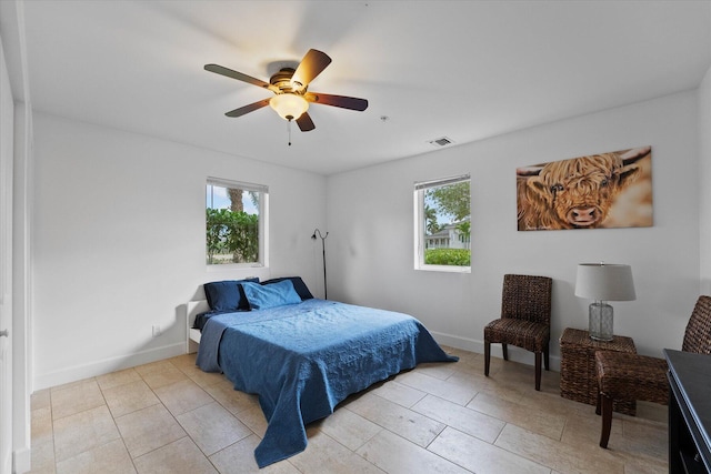 bedroom with light tile floors, multiple windows, and ceiling fan