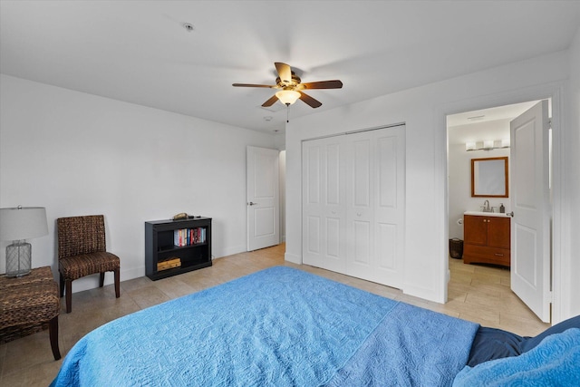 bedroom with connected bathroom, ceiling fan, sink, light tile flooring, and a closet