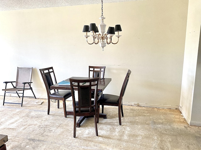 dining room with concrete floors, a notable chandelier, and a textured ceiling