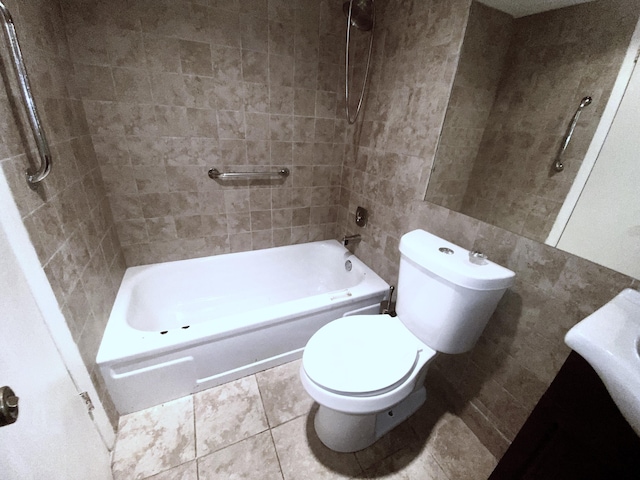 bathroom featuring toilet, tiled shower / bath, tile patterned floors, and tile walls