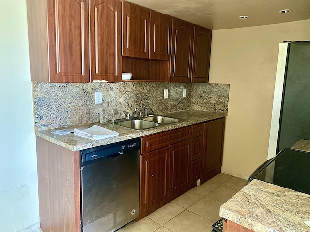 kitchen featuring light stone countertops, sink, light tile patterned flooring, stainless steel appliances, and decorative backsplash