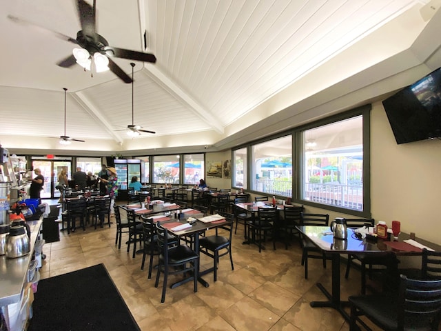 dining space featuring ceiling fan, light tile patterned flooring, and vaulted ceiling with beams