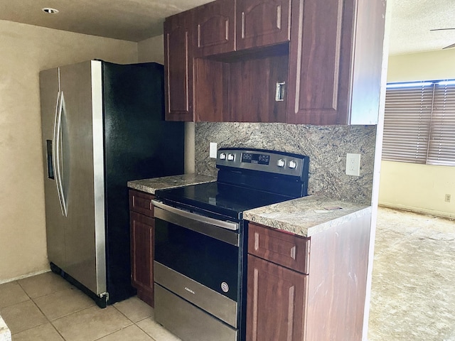 kitchen with stainless steel appliances, decorative backsplash, a textured ceiling, and light tile patterned flooring