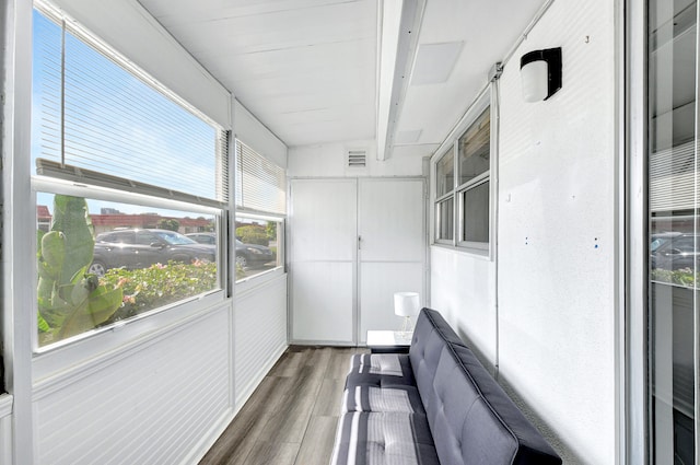 unfurnished sunroom featuring beamed ceiling