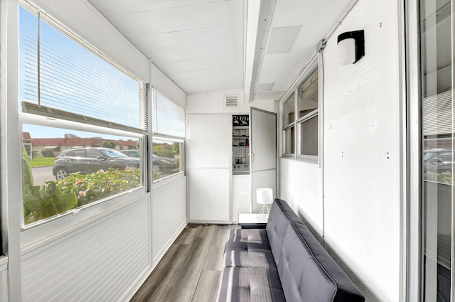 unfurnished sunroom featuring beamed ceiling