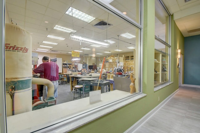 interior space featuring a workshop area and a drop ceiling