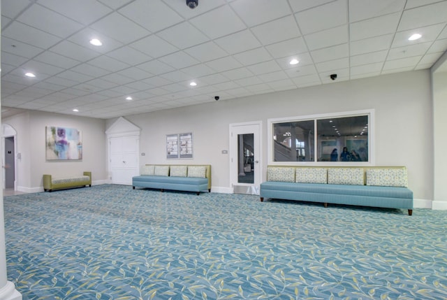 unfurnished living room featuring carpet flooring and a drop ceiling