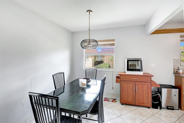 dining room with light tile flooring and a notable chandelier