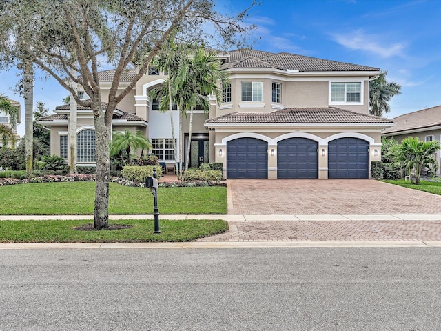 mediterranean / spanish house featuring a front yard and a garage