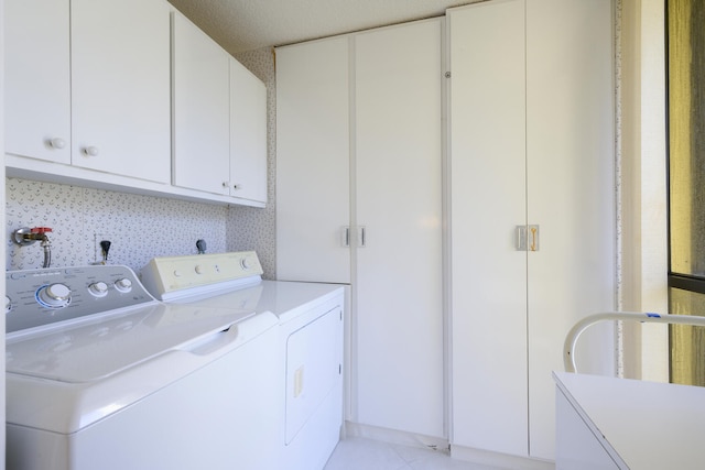 washroom featuring cabinets, a textured ceiling, washer and dryer, and light tile floors