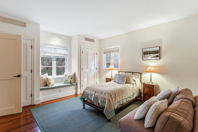 bedroom featuring multiple windows and dark wood-type flooring