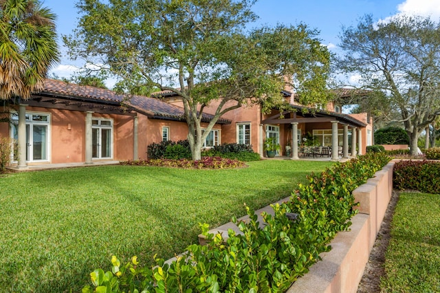 rear view of property featuring a lawn