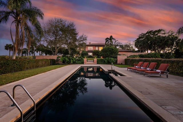 pool at dusk with a patio