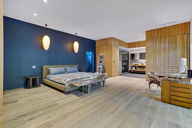 bedroom with wood walls and light wood-type flooring