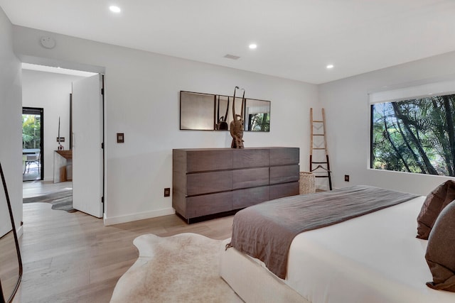 bedroom with multiple windows and light hardwood / wood-style floors