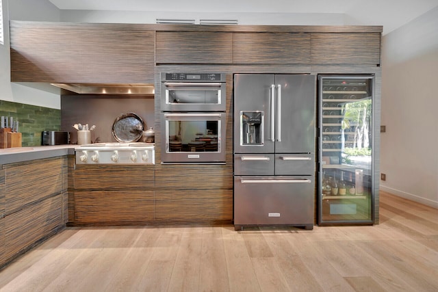 kitchen with tasteful backsplash, light hardwood / wood-style flooring, and appliances with stainless steel finishes