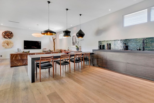 interior space featuring light hardwood / wood-style floors, decorative light fixtures, and sink