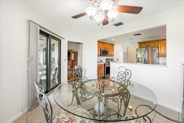 dining area featuring ceiling fan, light tile patterned floors, and a textured ceiling