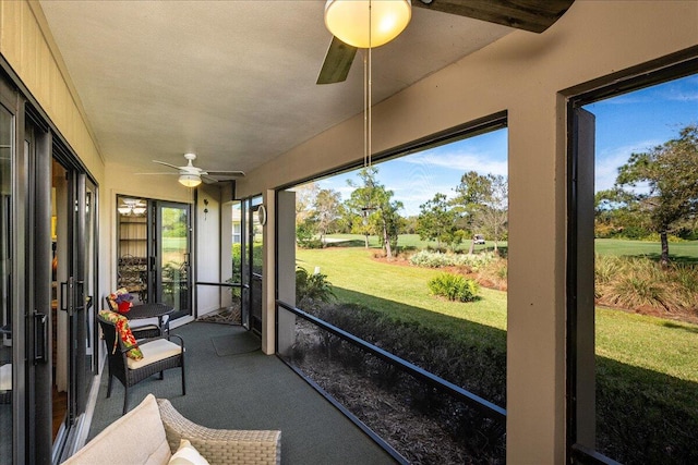 sunroom with ceiling fan and beamed ceiling