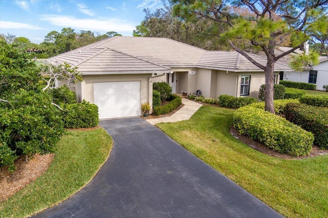 single story home featuring a front lawn and a garage